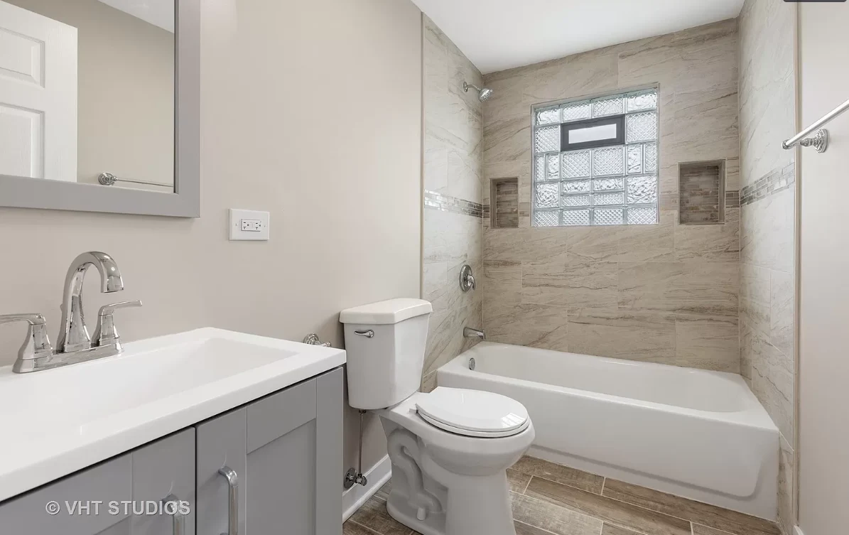 Finished full bathroom with tiled tub surround and modern vanity