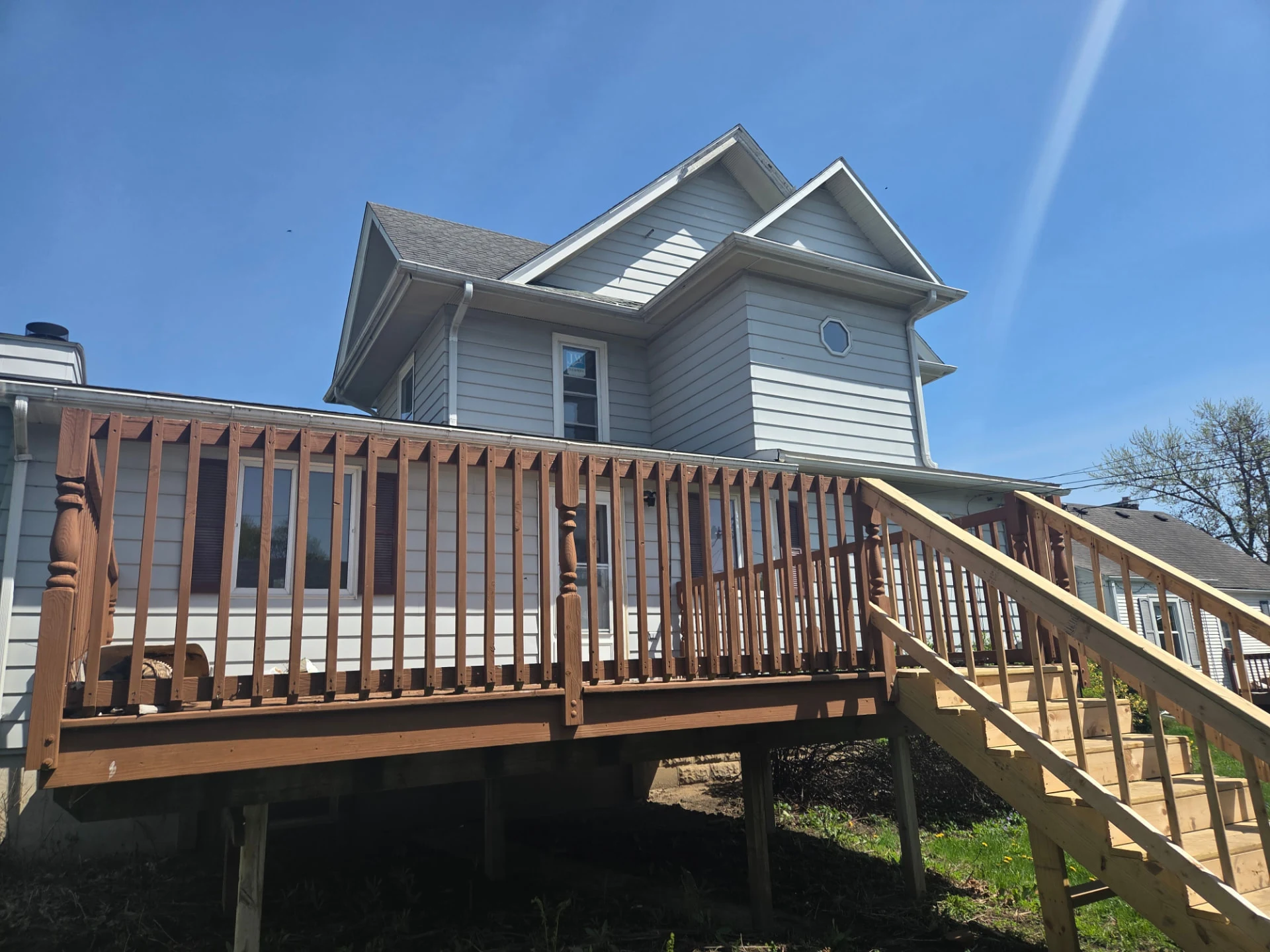Exterior view of the home with updated siding and completed deck