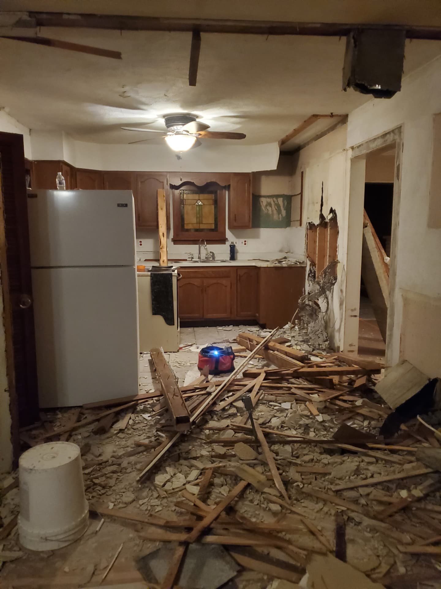 Original kitchen with dated cabinetry during early demolition