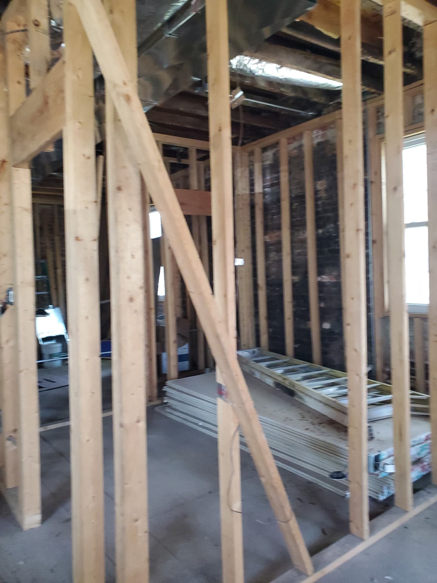 Interior framing with new wood studs and open ceiling joists during renovation