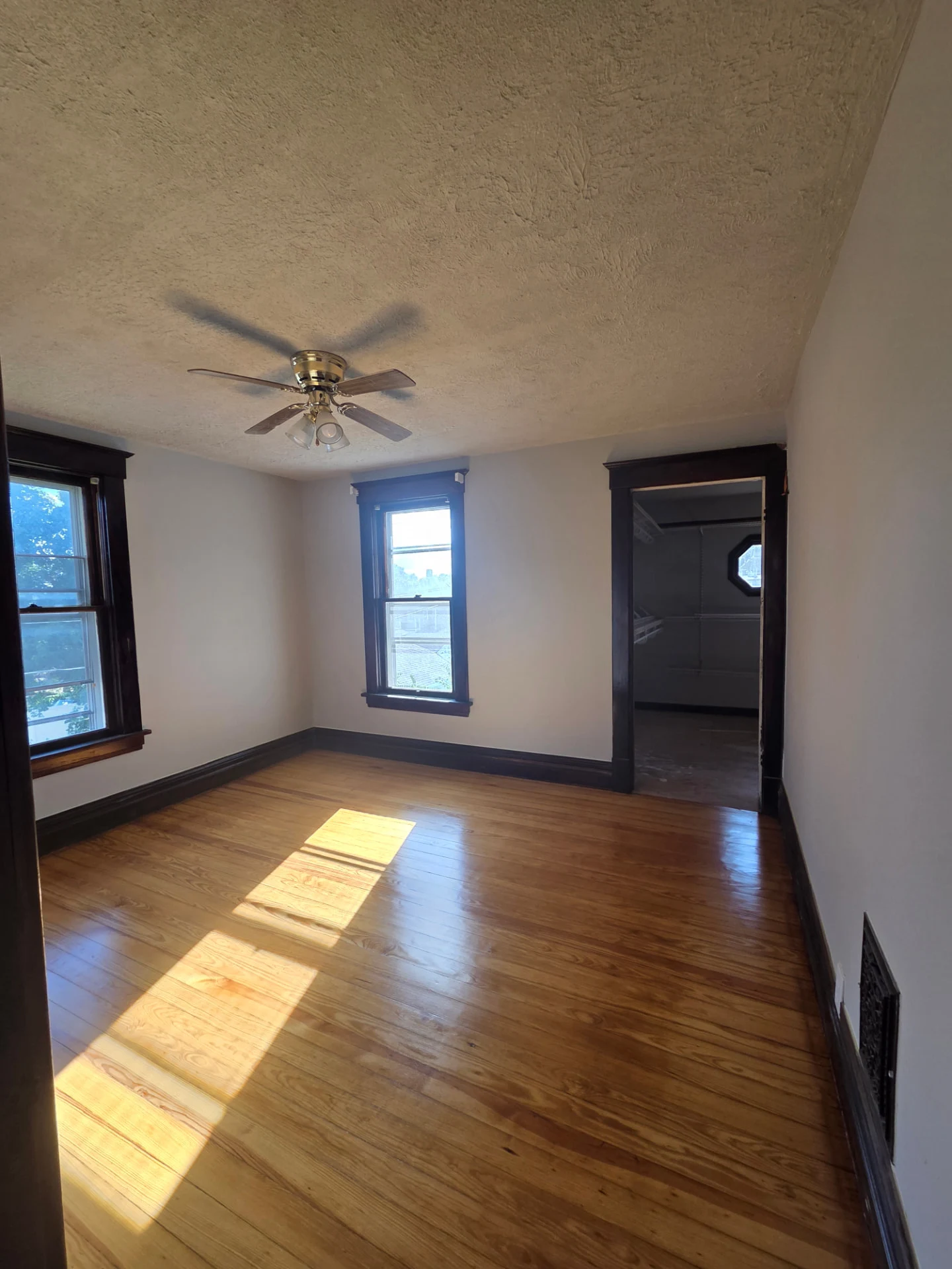 Bedroom with original hardwood floors and natural light before renovation work